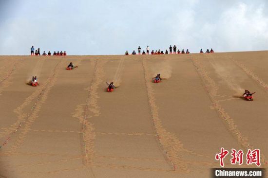 6月13日，敦煌鳴沙山月牙泉景區(qū)舉辦滑沙比賽。　張曉亮 攝