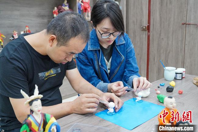 <a target='_blank'  data-cke-saved- >中新社</a>記者(右)現(xiàn)場(chǎng)體驗(yàn)面塑制作過程?！￡悹?zhēng)強(qiáng) 攝