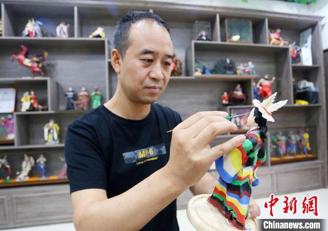 圖為安秋平正在創(chuàng)作代表隴南文縣民俗的《白馬人》作品。　高展 攝