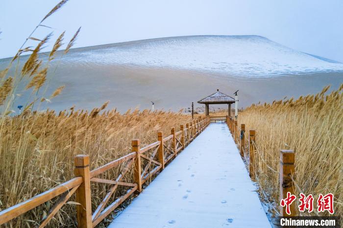 2021年11月28日，在敦煌鳴沙山月牙泉景區(qū)，沙雪交融，更顯北國(guó)風(fēng)情?！⊥醣筱y 攝