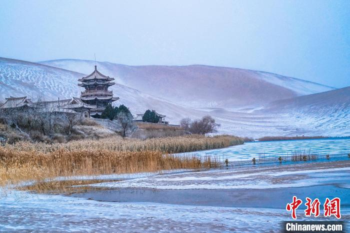 2021年11月28日，雪落鳴沙山月牙泉景區(qū)。　王斌銀 攝