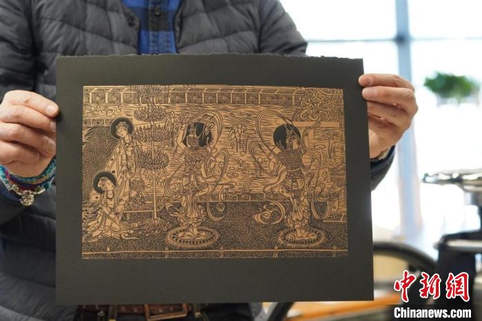 圖為手工書藝人展示敦煌雕版壁畫印刷品?！【琶赖┰?　攝