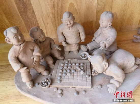 圖為泥塑作品展現(xiàn)下棋場(chǎng)景。 劉玉桃 攝