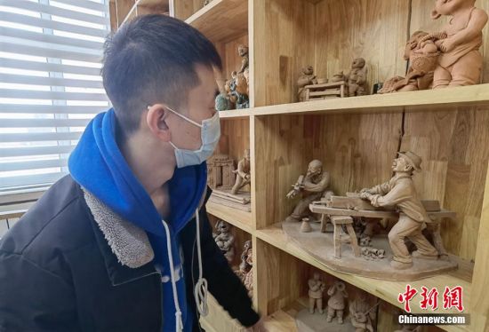 圖為學(xué)生欣賞泥塑作品。 劉玉桃 攝