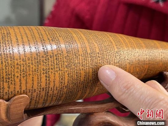 圖為長約二十公分的長條葫蘆雕刻佛教經(jīng)文作品。　張婧 攝