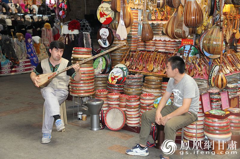 烏魯木齊二道橋巴扎內，店主正在向客人展示樂器。楊文遠 攝