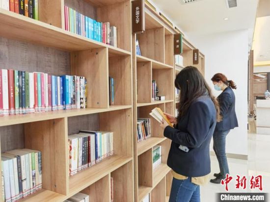圖為在甘肅公航旅建設集團有限公司的職工書屋，職工挑選書籍。　徐雪 攝
