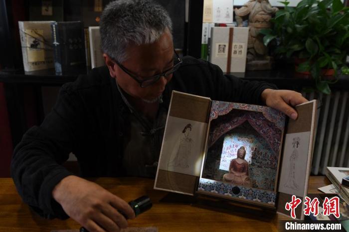 圖為讀者出版集團(tuán)讀者晉林工作室獨(dú)立出品人徐晉林，展示互動(dòng)性強(qiáng)的敦煌題材手工書(shū)。(資料圖) 楊艷敏 攝