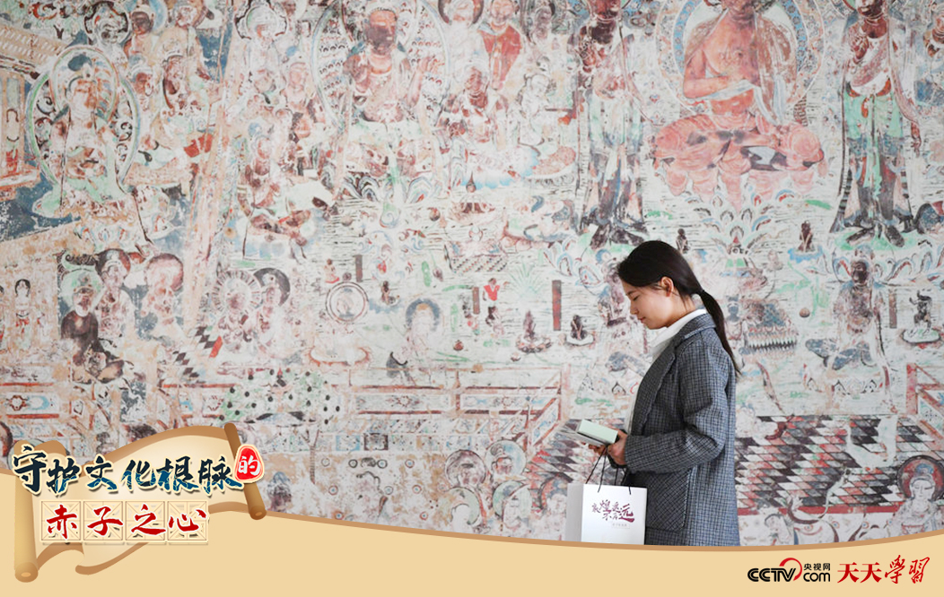 2023年4月25日，敦煌研究院文物數(shù)字化保護團隊創(chuàng)意營銷人員廖雪婷從一幅高保真復制壁畫前走過。