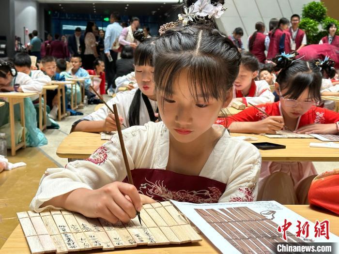 圖為小朋友在甘肅簡牘博物館練習(xí)書法?！≈行律缬浾?戴文昌 攝