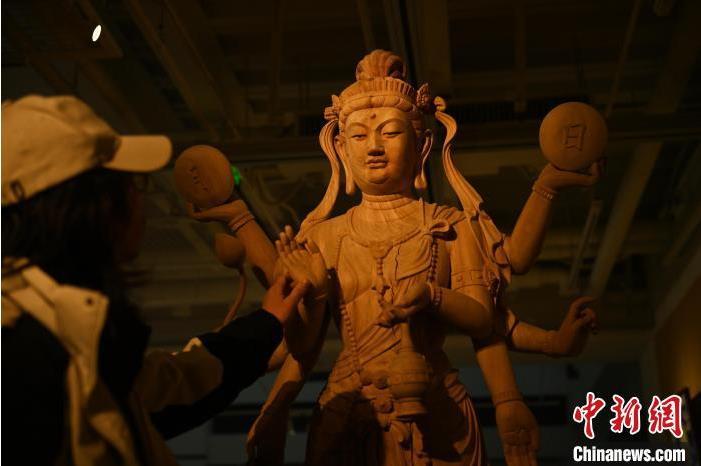 圖為季茂杰觀(guān)察自己創(chuàng)作的敦煌木雕。李亞龍 攝</p>
<p>