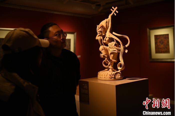 圖為季茂杰向參觀(guān)者介紹自己創(chuàng)作敦煌木雕的過(guò)程。李亞龍 攝</p>
<p>
