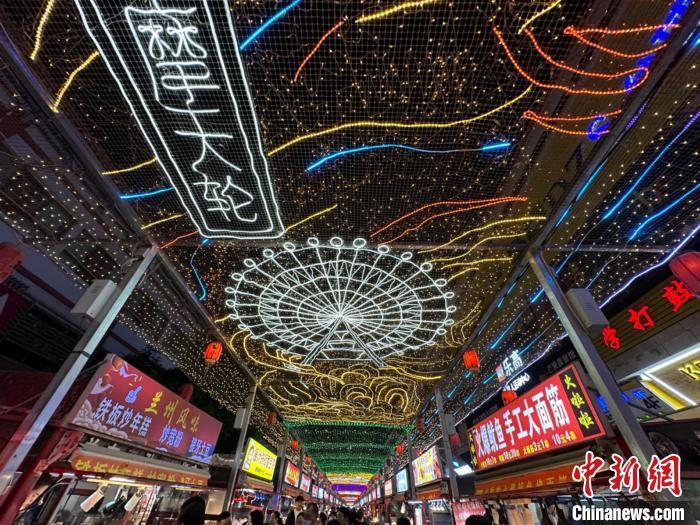 圖為明清街夜市燈光點(diǎn)亮具有武威文化元素的“摩天輪”彩燈。　戴文昌 攝</p><p>