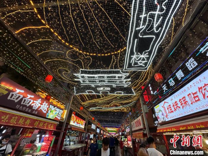 圖為明清街夜市燈光點(diǎn)亮具有武威文化元素的“涼州古城門”彩燈?！〈魑牟?攝</p><p>