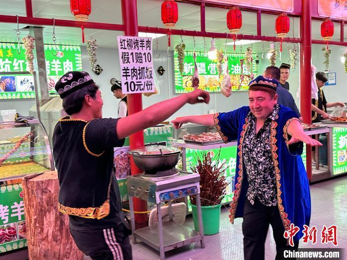 圖為餐飲經(jīng)營(yíng)者在“西涼不夜城”跳起舞蹈引客?！〈魑牟?攝</p><p>