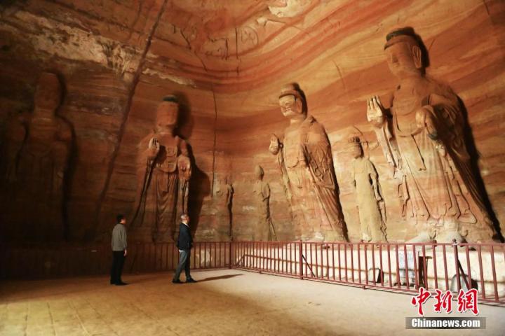7月15日，游人參觀甘肅省平?jīng)鍪袥艽h百里石窟長廊中的南石窟寺1號窟。百里石窟長廊位于涇川縣境內(nèi)，由512個(gè)石窟、5眼窟中石井組成，現(xiàn)存王母宮石窟、鳳凰山石窟、南石窟寺、丈八寺石窟、羅漢洞石窟、太山寺石窟等規(guī)模較大的石窟群，還有數(shù)量眾多的小石窟群。南石窟寺開鑿于北魏永平三年，其中1號窟屬于大型七佛窟，七佛高達(dá)6米。中新社記者 李亞龍 攝